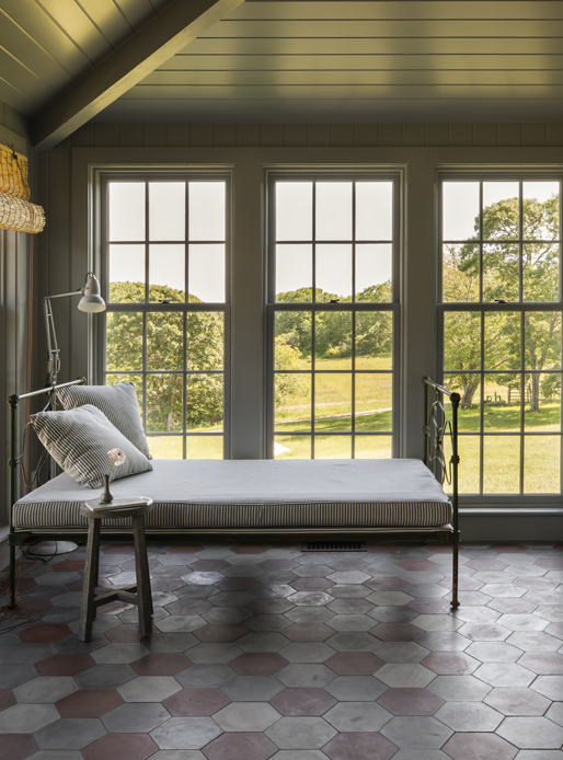 Cottage sunroom with wall to wall windows with grilles